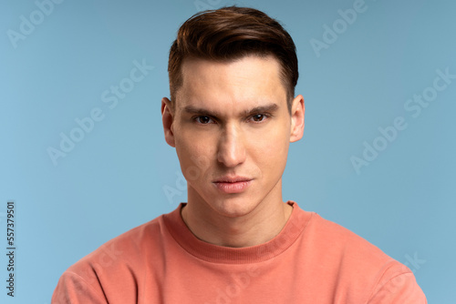 Portrait of attentive self confident man looking at camera with serious expression