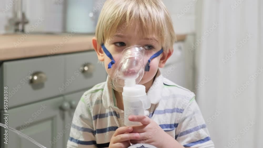 Sick Baby Boy with making Inhalation with a Mask on his Face sitting in Living Room at Home. Children Healing. Child Inhalation therapy with Compressor nebulizer. Inhaling fumes medication into lungs Sick Baby Boy with making Inhalation with a Mask on his Face sitting in Living Room at Home. Children Healing. Child Inhalation therapy with Compressor nebulizer. Inhaling fumes medication into lungs