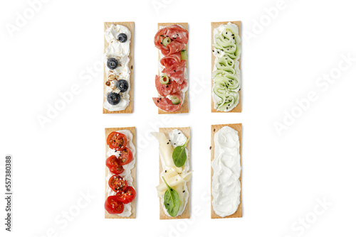 Set of assorted sandwiches on grain crispbreads, snack, toasts, bruschetta with cream cheese, salami, cucumber, blueberry.