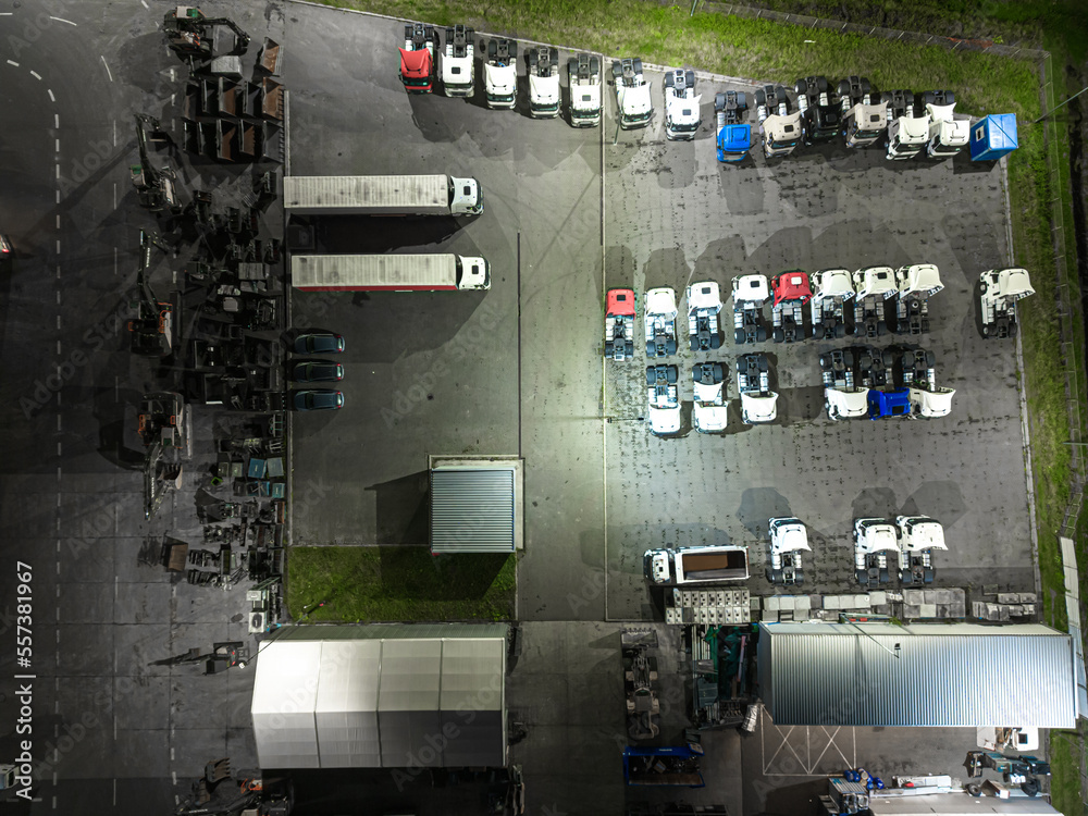 Aerial view of goods warehouse Night. Logistics center in industrial city zone from above. Aerial view of trucks loading at logistic center Aerial view of goods warehouse Night. Logistics center in industrial city zone from above. Aerial view of trucks loading at logistic center