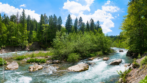 Panoramic view on small river island in Breitach River on summer day