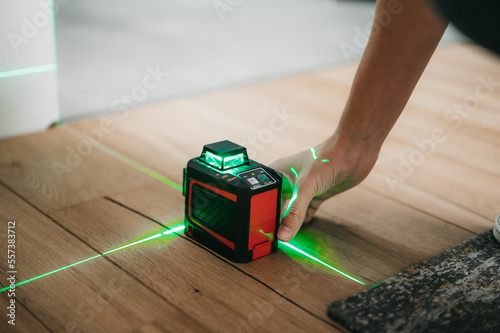 Builder and handyman using laser leveler to measure and draw lines and check interior