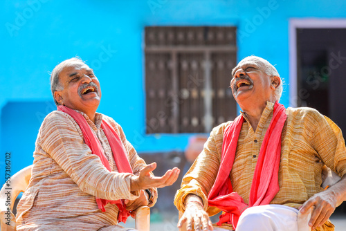 Two indian old farmer discussing at out of home. photo