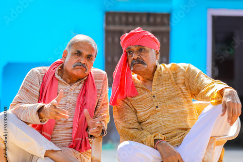 Two indian old farmer discussing at out of home.
