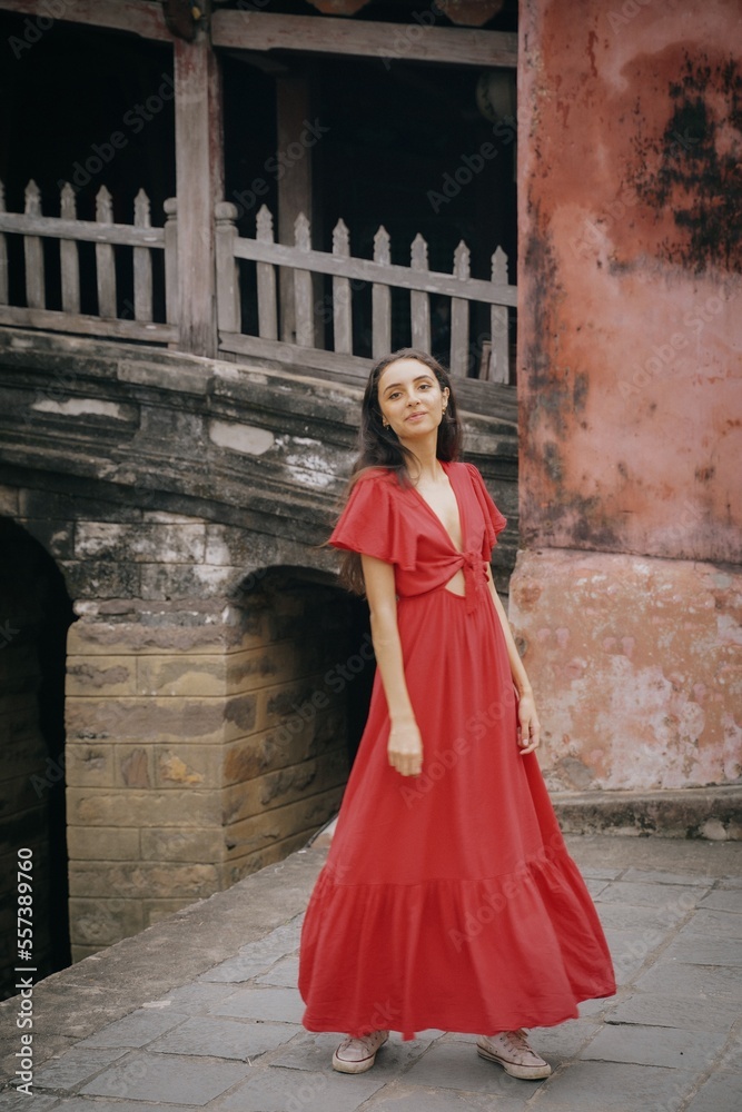 tourist girl in red dress on Cau Temple bridge, hoi an ancient town in vietnam