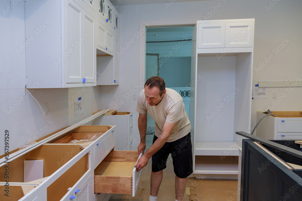 Working on kitchen cabinet draw in new home by carpenter Working on kitchen cabinet draw in new home by carpenter