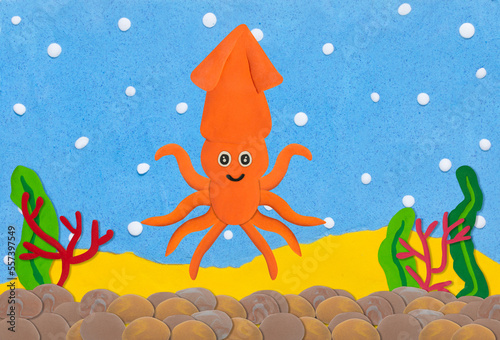 orange squid made from plasticine on under water background