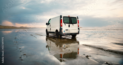 Foto Camper van driving next to the wadden sea at low tide, traveling at the beach of
