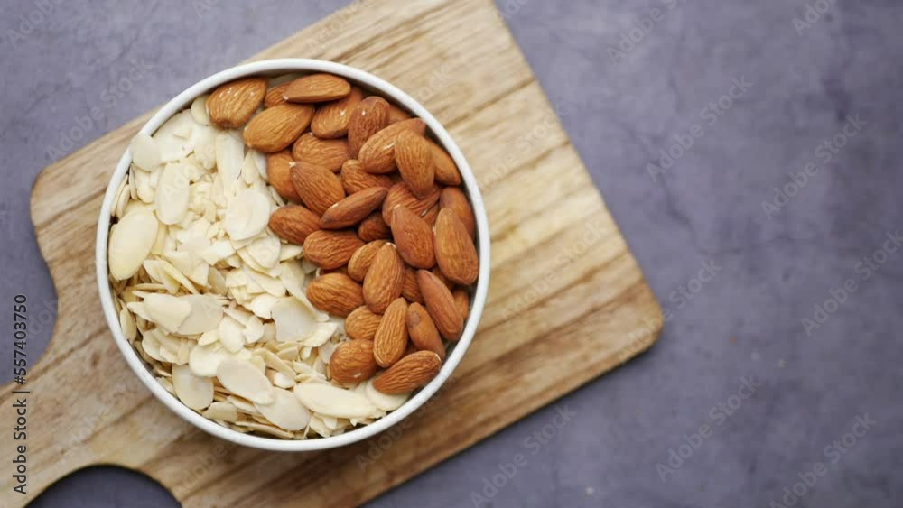 top view of almond nut and slice in a bowl on table top view of almond nut and slice in a bowl on table