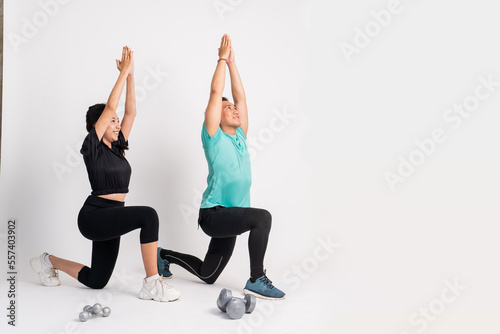 a man and woman squatting with their hands together up on a white background