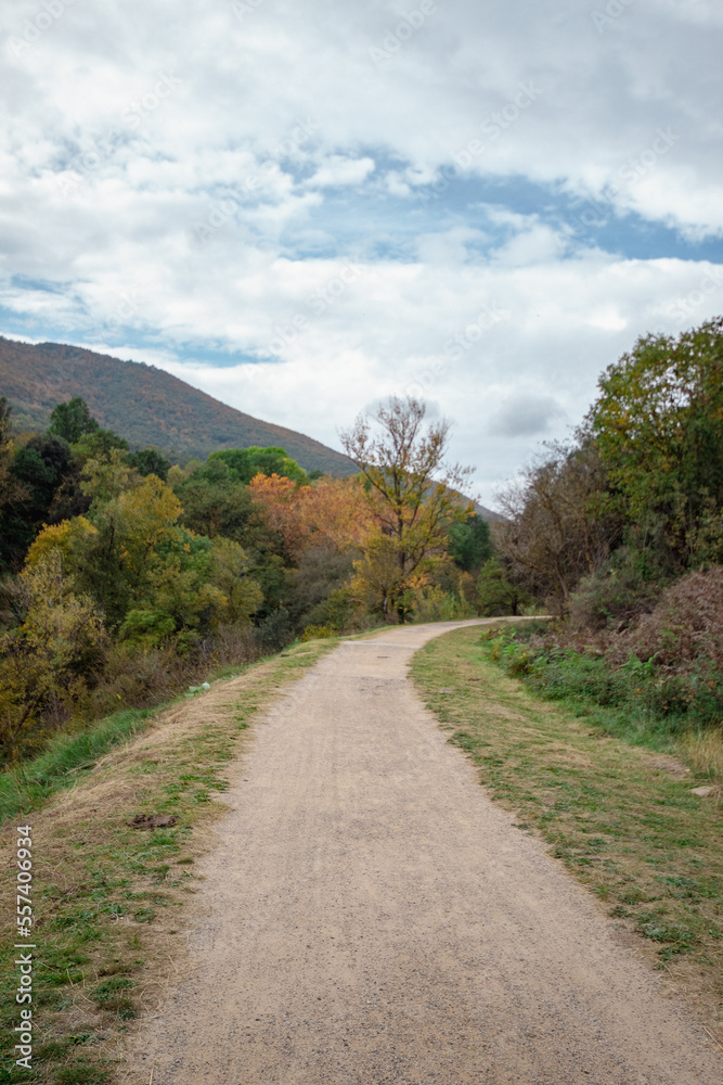 Camino de tierra del sendero de la montaña de Cataluña para ver las cascadas del frío agua con un cielo nublado en un fío día de Noviembre.