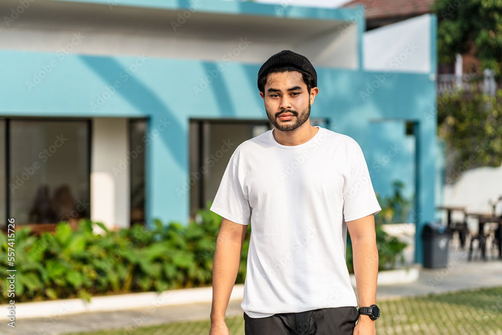 A young bearded handsome man doing a pose while wearing his white blank shirt A young bearded handsome man doing a pose while wearing his white blank shirt