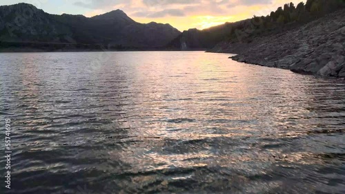 Lake with mountains at sunset, recorded from a drone