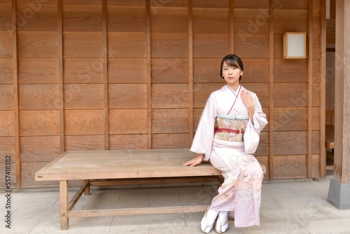 椅子に座ってポーズをとる若く美しい着物姿の女性