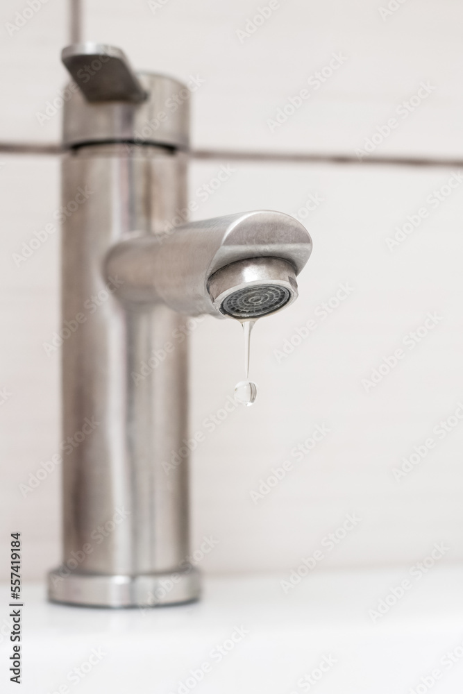 Water dripping from the faucet in the bathroom. Water faucet close-up. Saving water Water dripping from the faucet in the bathroom. Water faucet close-up. Saving water