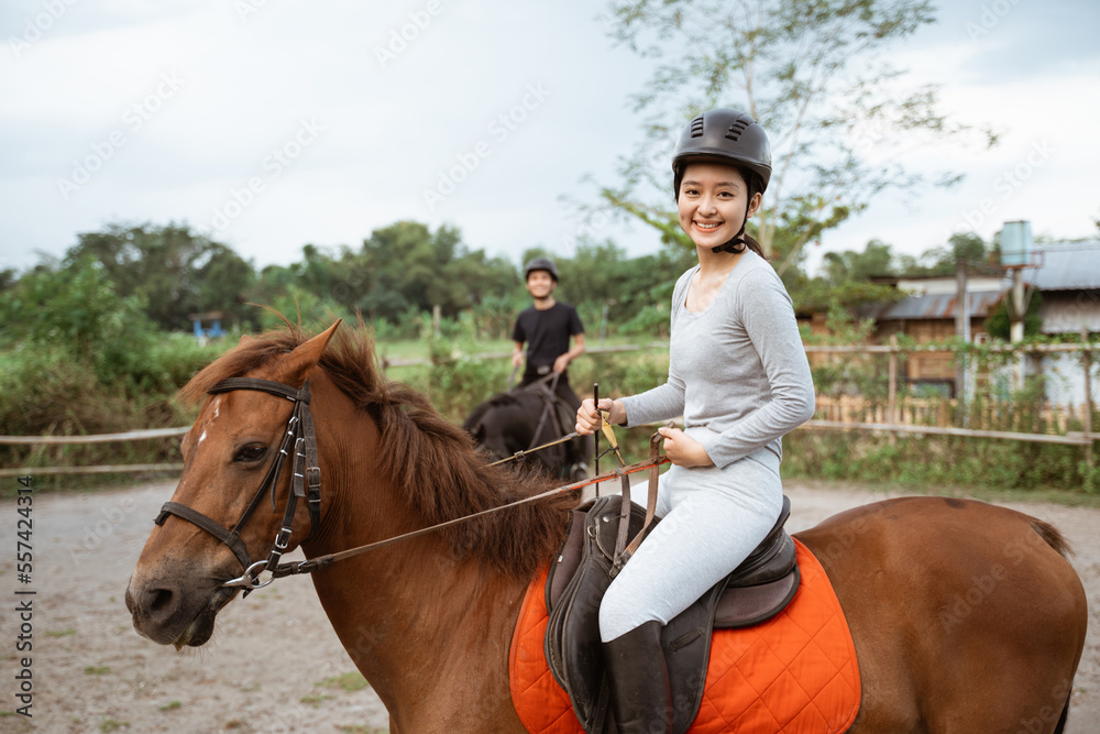 female athlete riding horse to train with male athlete on outdoor background female athlete riding horse to train with male athlete on outdoor background