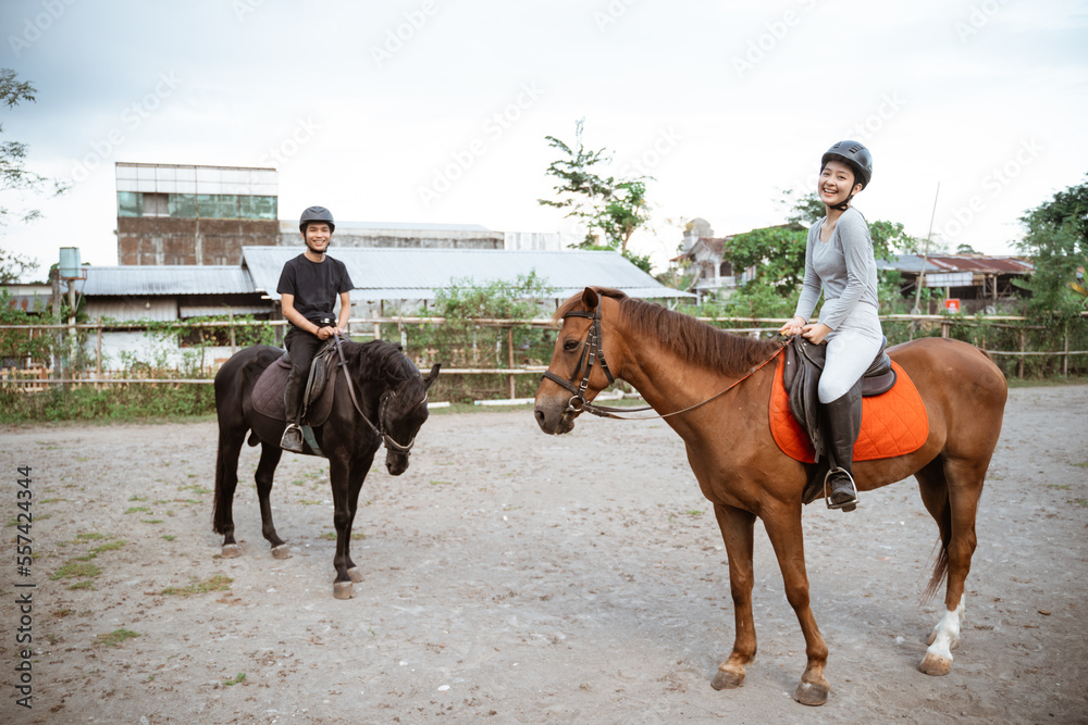 two asian equestrian athletes meet during equestrian practice in outdoor background two asian equestrian athletes meet during equestrian practice in outdoor background