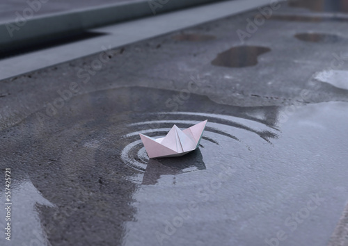 Origami. Paper boat on a puddle (ID: 557425721)