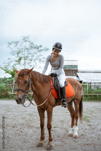 Equestrian athletes ride horses and stroke horses after competing in the field arena