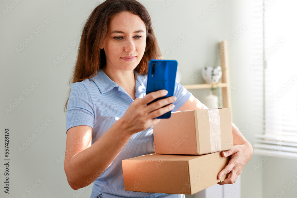 Young woman holding cardboard parcel, receiving desired delivery, getting her online order at home Young woman holding cardboard parcel, receiving desired delivery, getting her online order at home