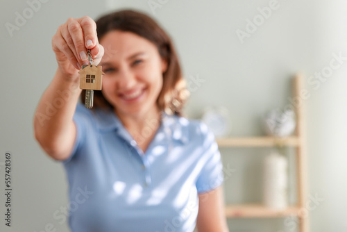 Young woman moving into new house showing her keys