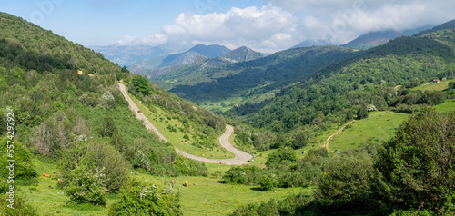Vistas panorámicas del paisaje del Valle de Somiedo en Asturias, con  carreteras serpenteantes atravesando montañas verdes, al fondo un cielo azul con nubes blancas en un entorno natural, verano 2021 