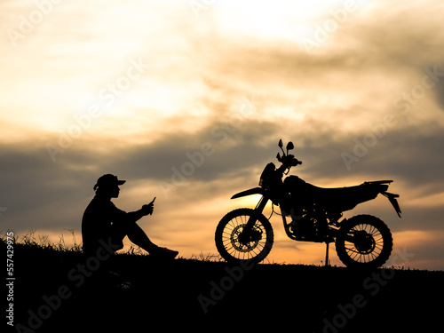silhouette of biker and motorcycle on sunset
