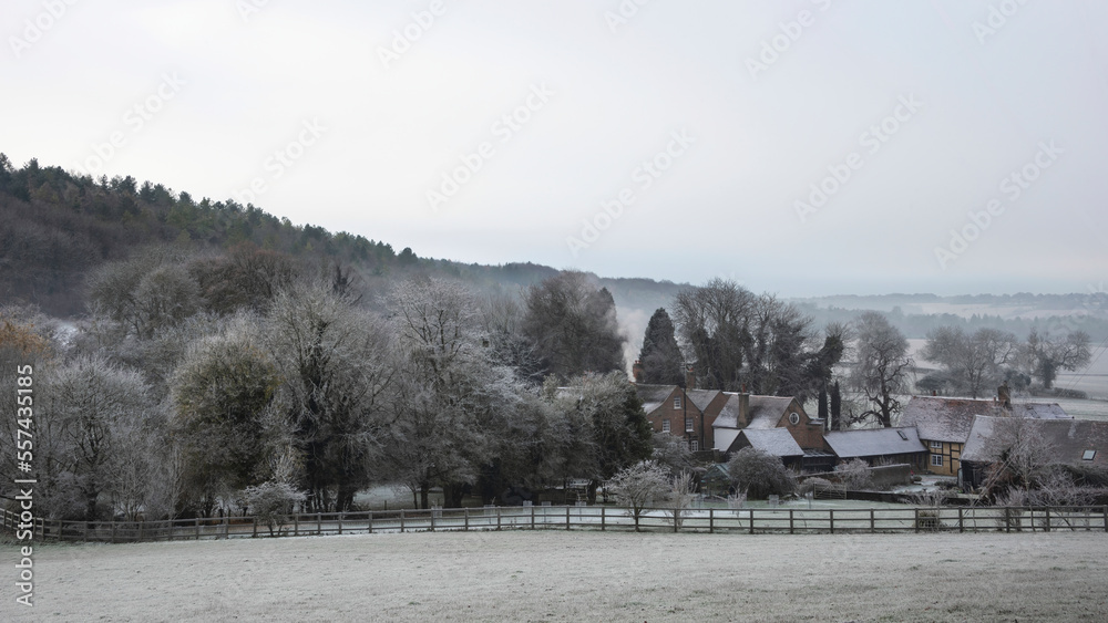 Beautiful Winter landscape of farm in fog in English countryside at dawn with hoarfrost covering trees and buildings Beautiful Winter landscape of farm in fog in English countryside at dawn with hoarfrost covering trees and buildings
