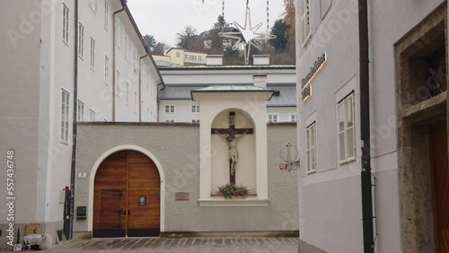 Salzburg Franziskanergasse street with religious cross at monastery wall photo