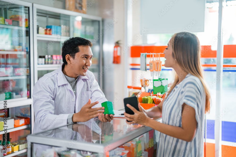 male pharmacist giving medicine to female customer at the pharmacy