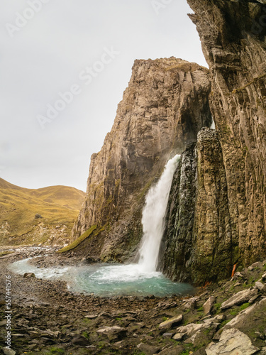 Autumn mountains in autumn morning. Gil-Su waterfall in wide autumn valley in North Caucasus, Russia. Beautiful vertical landscape.