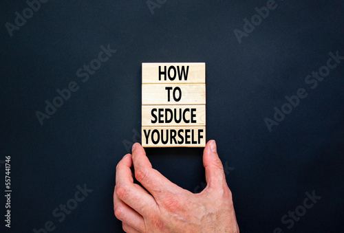 How to seduce yourself symbol. Concept word How to seduce yourself on wooden blocks. Businessman hand. Beautiful black table black background. Business and how to seduce yourself concept. Copy space.