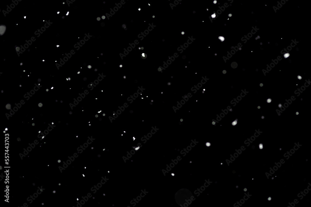 Bokeh effect of snowfall and lights. Abstract blurred background with snowflake in the night sky, White spots and dots in the dark. Snowy stormy weather, falling snow