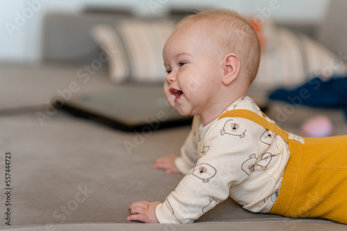 Cute happy baby crawling on the sofa in the living room