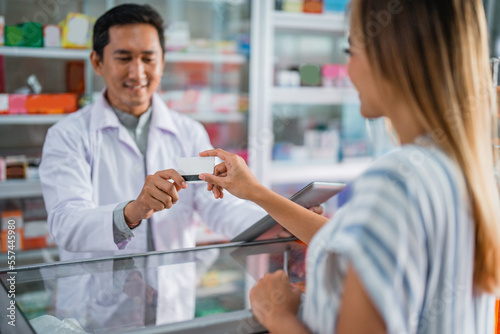 a customer uses a credit card to buy medicine at a drugstore