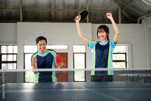 ping pong doubles players excited when they score at the ping pong table photo