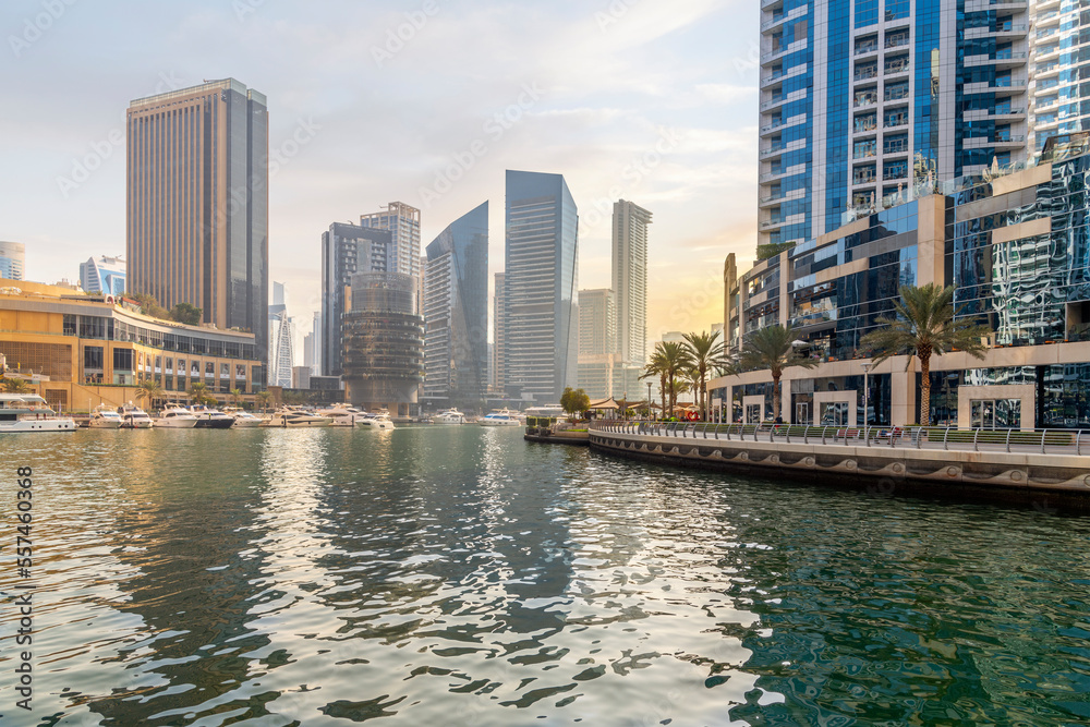 Late afternoon as the sun sets behind the Dubai Marina, a waterfront promenade of shops, boat marinas and skyscrapers, along the coast of Dubai, United Arab Emirates.