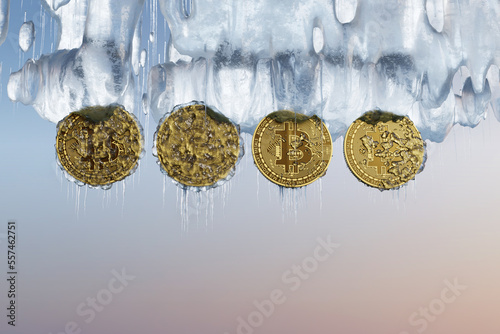 Frozen bitcoins with icicles in an ice cave at sunset. Illustration of the concept of the winter of cryptocurrencies, crash and unreliability of crypto exchanges photo