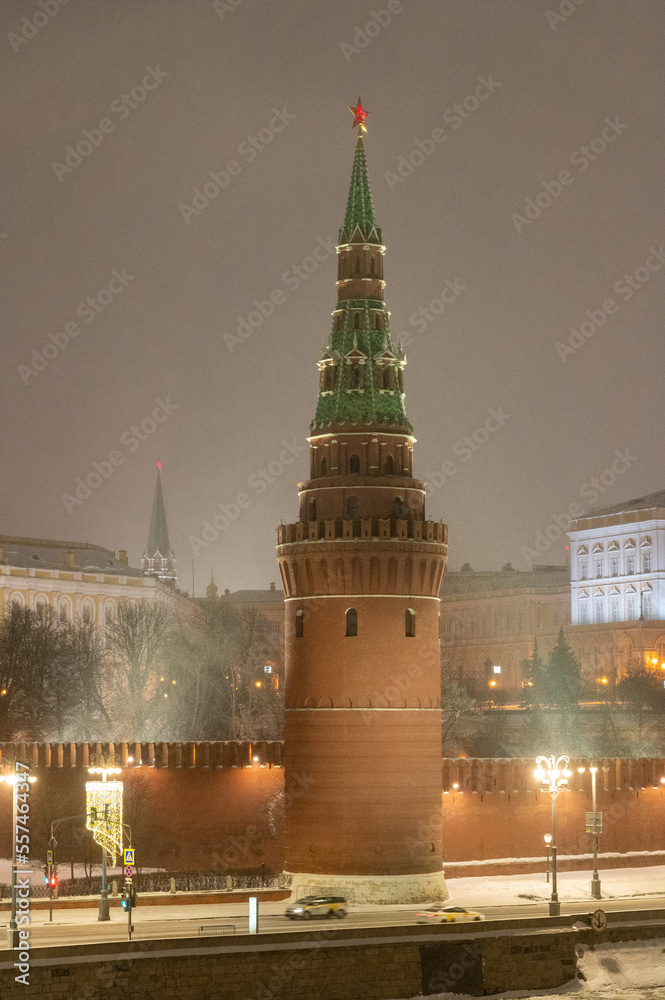 Moscow, Russia - December 27, 2022: Tower of the Moscow Kremlin. Cold and deserted Moscow street on a snowy winter evening near Red Square