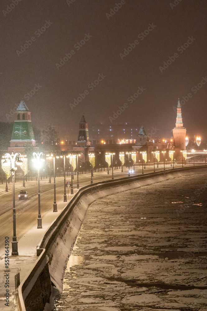 Moscow, Russia - December 27, 2022: Tower of the Moscow Kremlin. Cold and deserted Moscow street on a snowy winter evening near Red Square