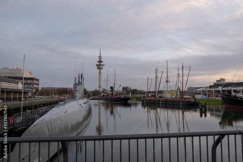 Fototapeta premium Sunset in Bremerhaven with houses and ships and the (bremer Schiffahrts-Museum), Klimahaus and the coast line of Bremerhaven (technik museum) taken from 90 m high bulding, Monochrom, sepia, panorama 