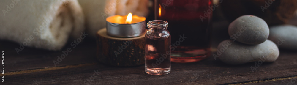 Concept of natural essential organic oils, Bali spa, beauty treatment, relax time. Atmosphere of relaxation, pleasure. Candles, towels, dark wooden background. Alternative oriental medicine. Banner Concept of natural essential organic oils, Bali spa, beauty treatment, relax time. Atmosphere of relaxation, pleasure. Candles, towels, dark wooden background. Alternative oriental medicine. Banner