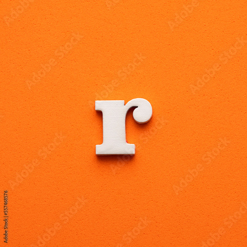 r white lowercase letter - Background in orange foamy photo