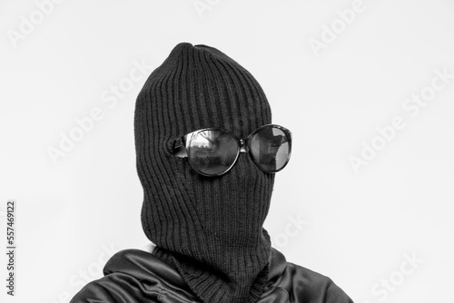 Hat balaclava on a girl and sunglasses on a white background, the face of a thief in a hat with a slit for verbs, a hacker photo