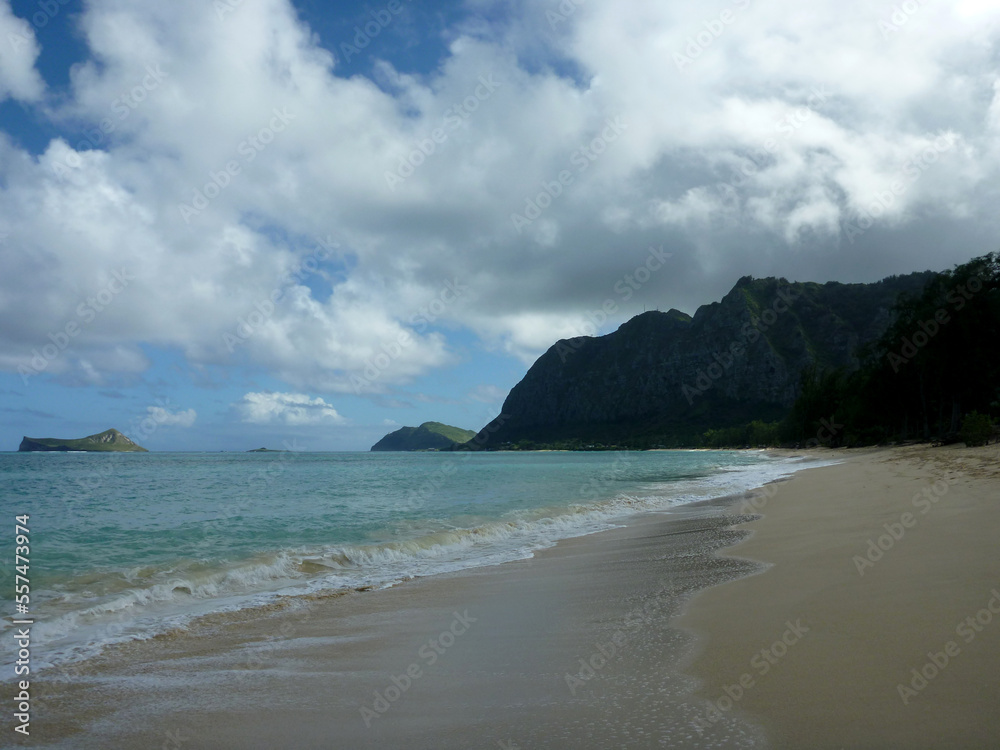 Gentle wave lap on Waimanalo Beach looking towards Rabbit island and Rock island on a nice day with clouds in the sky Gentle wave lap on Waimanalo Beach looking towards Rabbit island and Rock island on a nice day with clouds in the sky