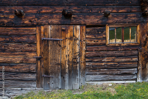 Exterior view on an old and weathered timber cottage with a wooden door and window
