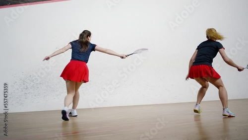 Female athletes compete in skill by playing squash photo