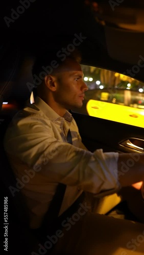 Businessman driving car in night city