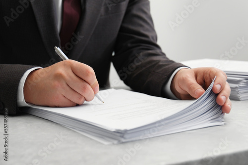Man signing document at table in office, closeup © New Africa