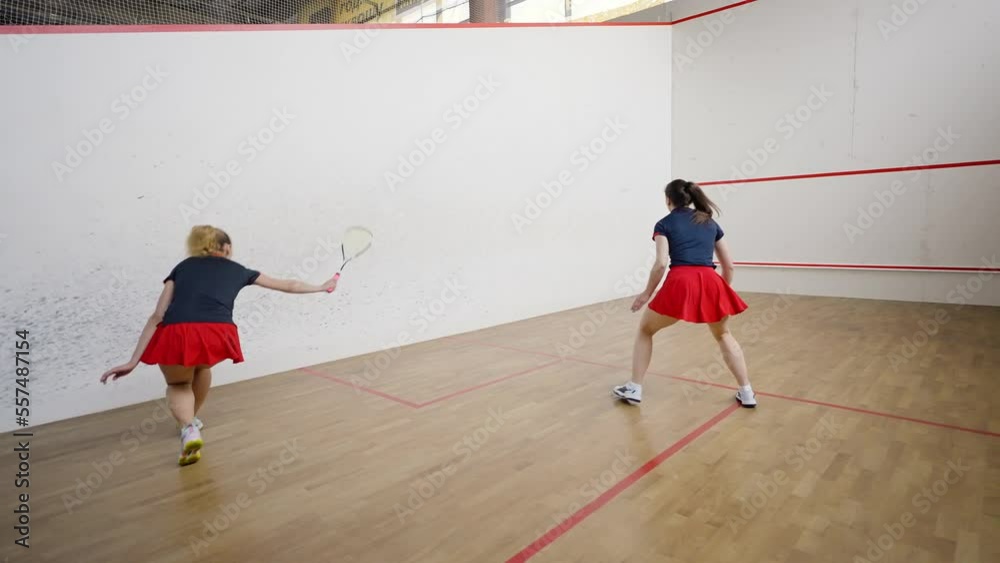 Fit women enjoy squash training together practicing skills Fit women enjoy squash training together practicing skills